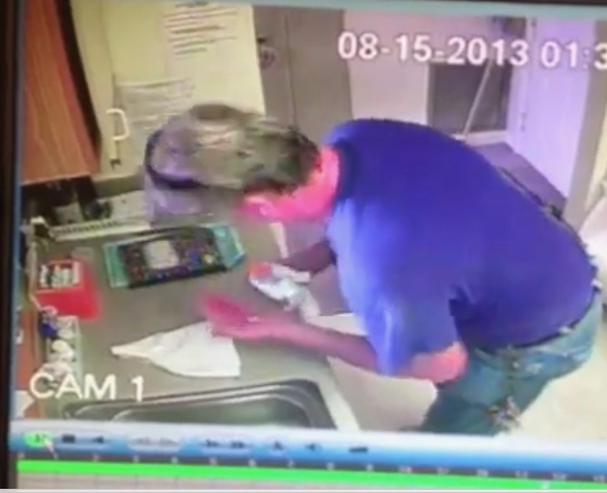 A screen grab from a hidden security camera of handyman taking pills from a bottle.